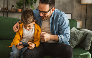 Un père et son enfant s’amusent sur un jeu vidéo mobile