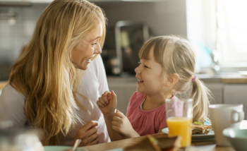 Une mère et son enfant déjeunent ensemble.