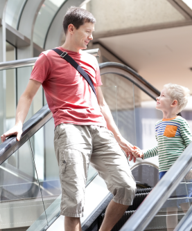 Enfant qui tient la main de son père dans un lieu public pour ne pas se perdre