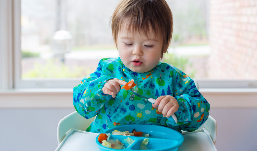 Learning to use utensils and drink from a cup